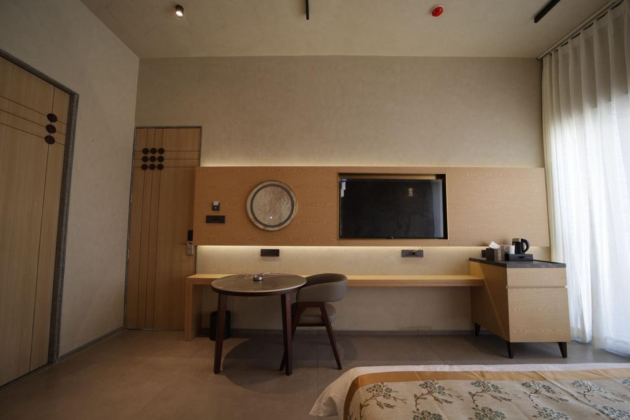 Oak media wall, writing ledge and round table in a guest suite