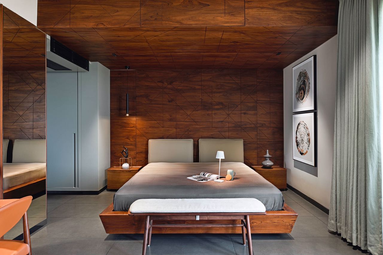 MA HOME bedroom with inlaid geometric teak ceiling, low timber bed and paired tree-ring prints
