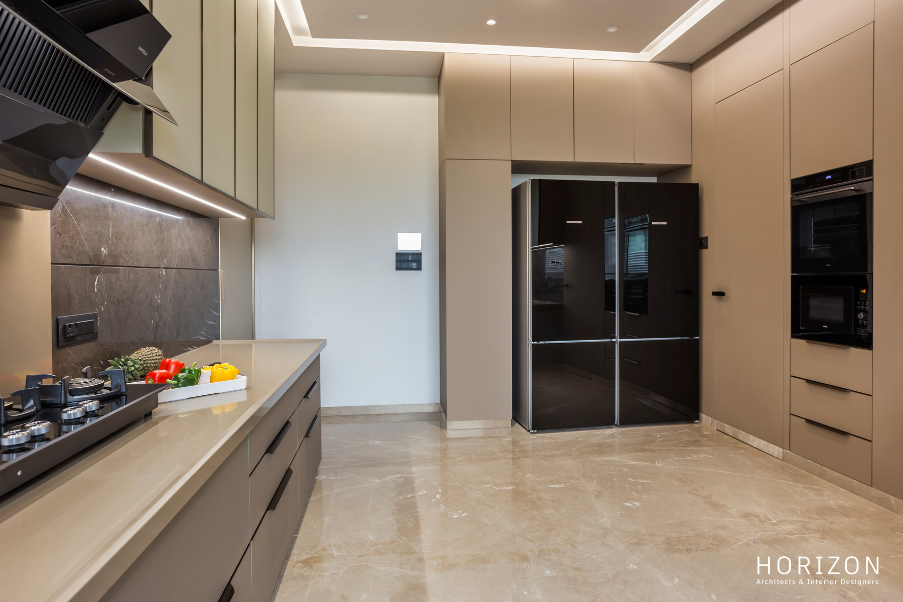 RAHUL BHAI HOME kitchen with sage-grey cabinetry, black refrigerator, built-in ovens and marble backsplash