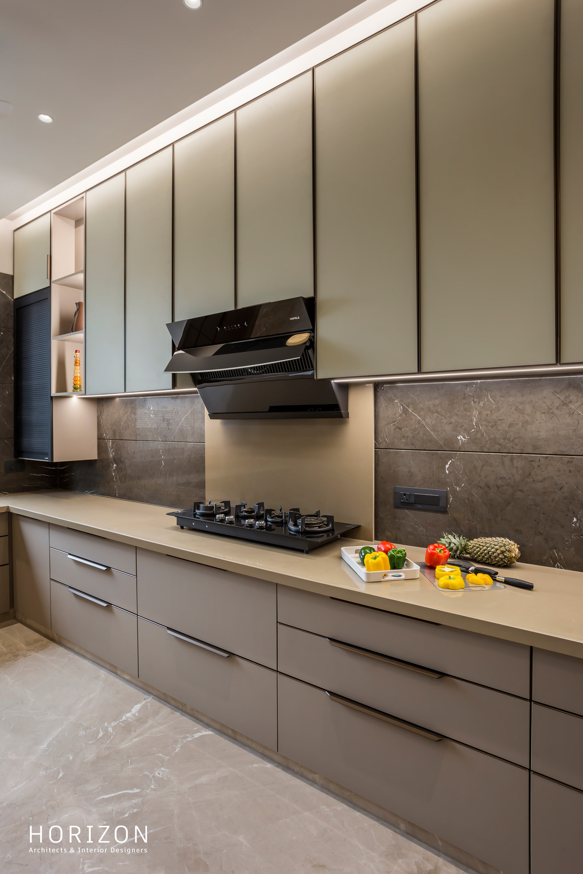 RAHUL BHAI HOME kitchen hob run with chimney, grey stone splashback and handleless drawers