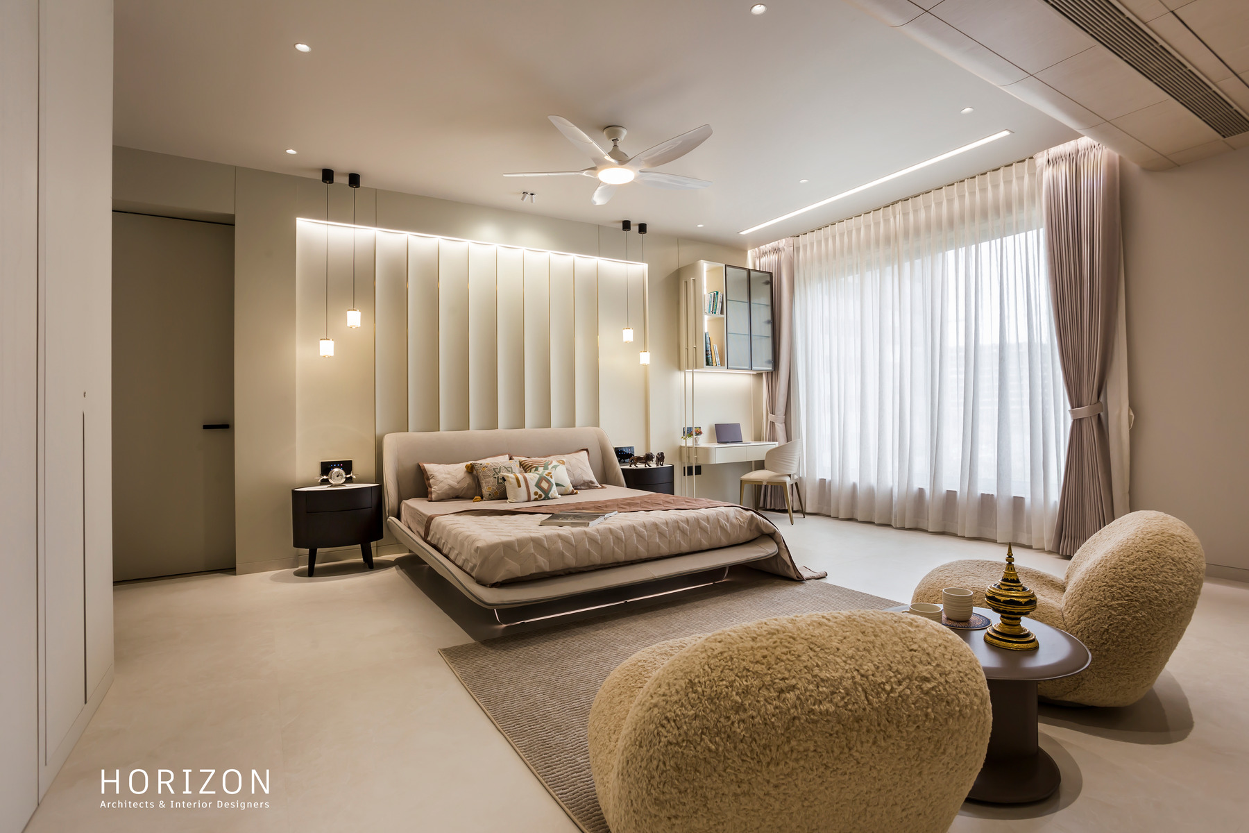 RAHUL BHAI HOME guest bedroom with fluted headboard wall, low bed and two boucle armchairs