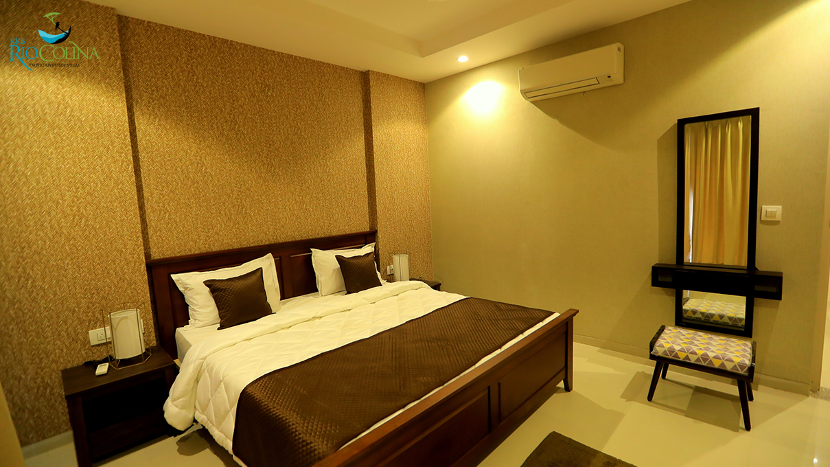Villa bedroom with dark timber bed and woven wallpaper