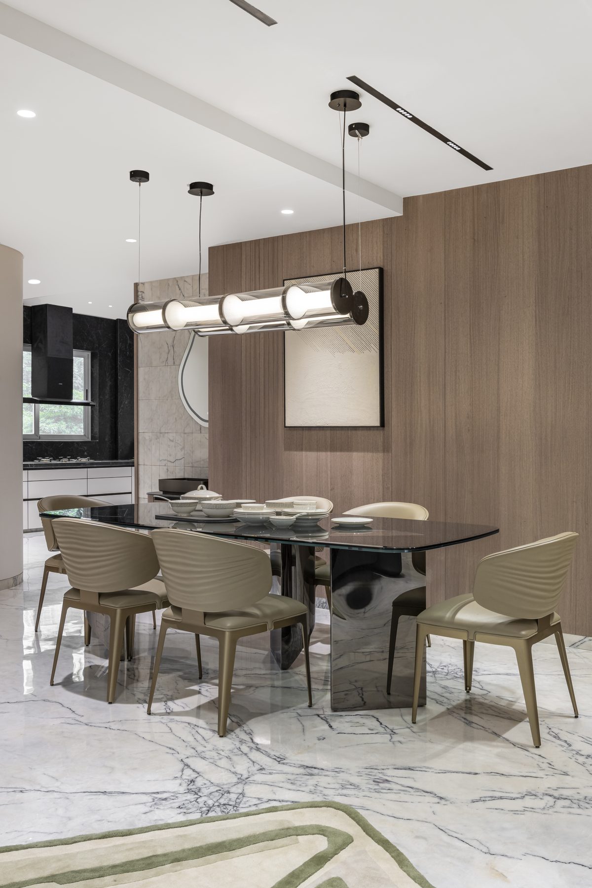 SACHIN BHAI HOME dining area with timber panelling and kitchen beyond