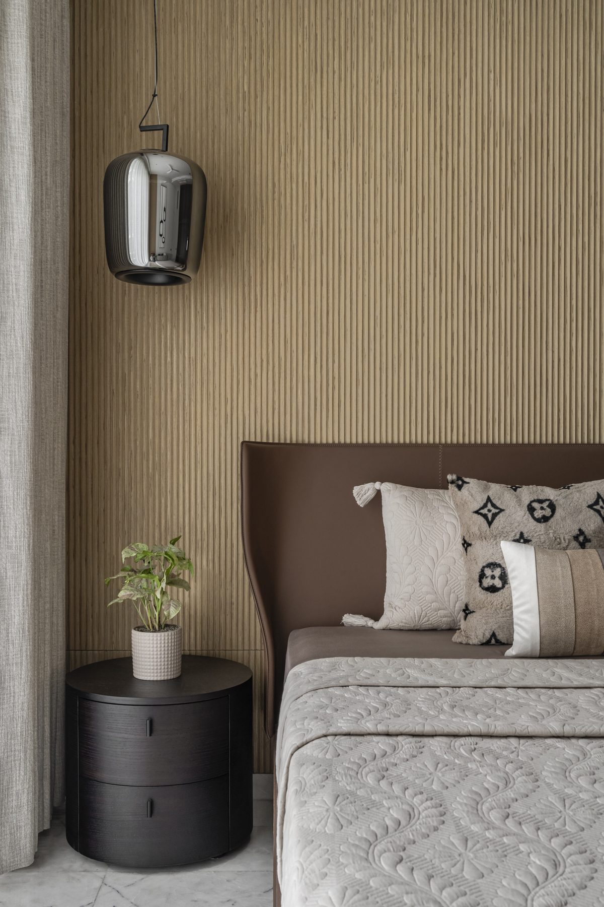 SACHIN BHAI HOME primary bedside with plant, round nightstand and chrome pendant