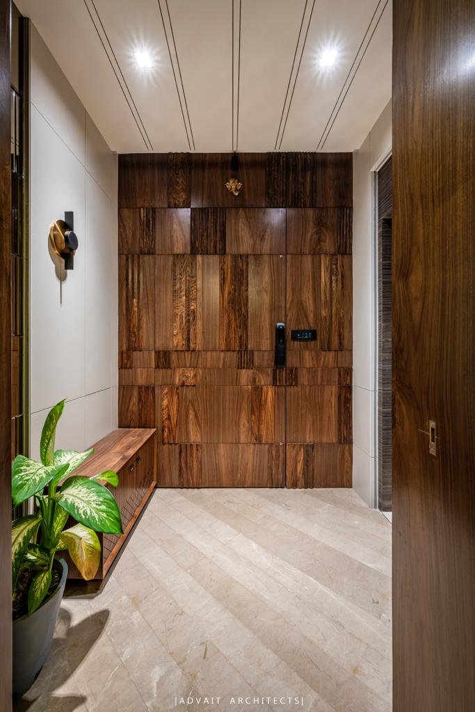VILLASHBHAI HOME entrance corridor with a full-height timber door and planted ledge