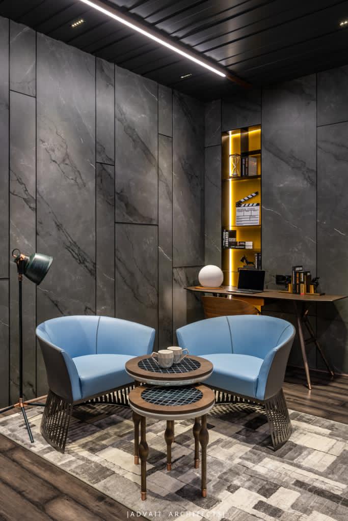VILLASHBHAI HOME study nook with paired blue tub chairs and a brass-topped table