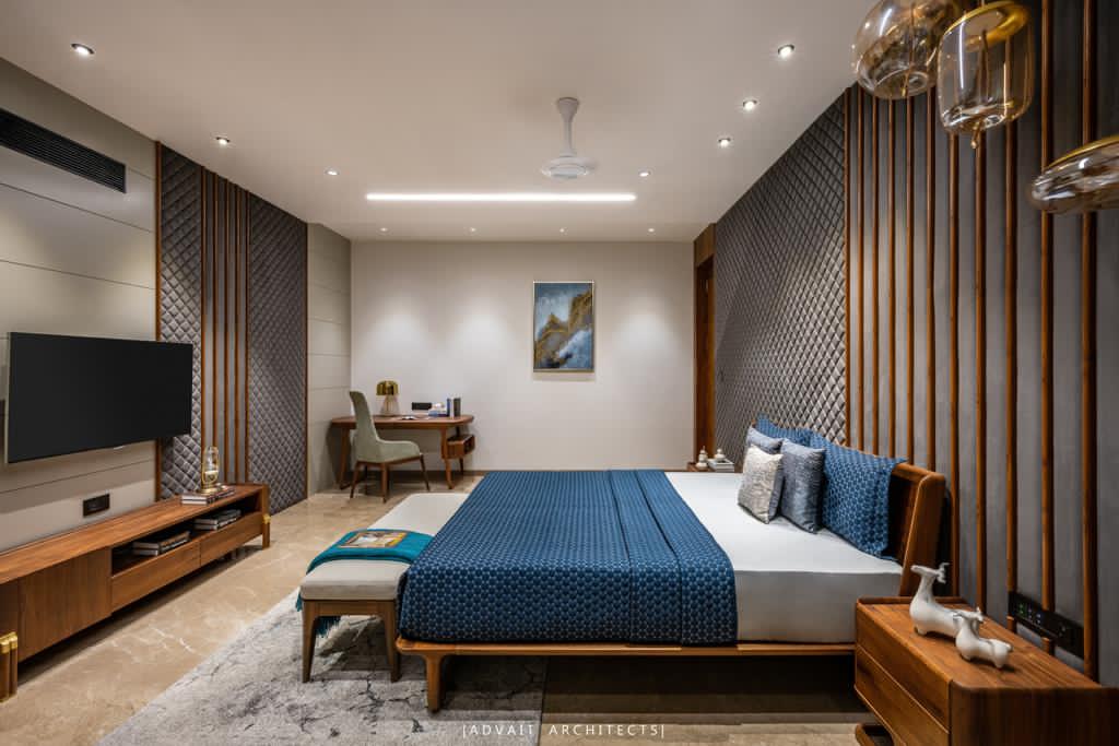 VILLASHBHAI HOME bedroom with slatted timber wall, blue bedding and a wall-mounted TV