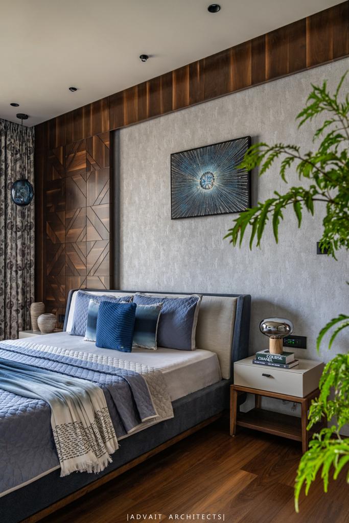 VILLASHBHAI HOME bedroom with blue bedding, timber panelling and trailing planting