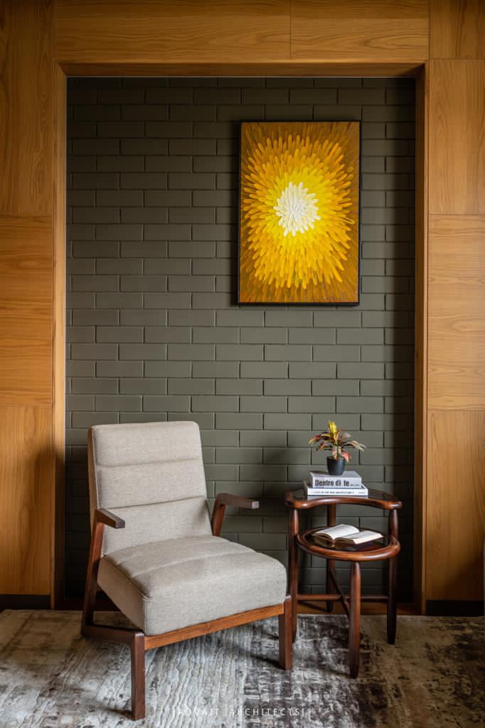 VILLASHBHAI HOME reading nook with an upholstered chair below a framed yellow artwork